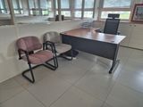 two chairs and a desk in a room with windows