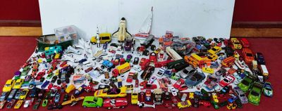un tas de petites voitures par terre, près d'un mur