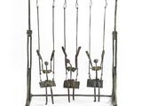 an image of a metal swing set with four people on it