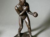 statue d'un homme tenant une batte de baseball et une balle sur une base