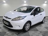 La Ford Fiesta blanche est garée sur un sol en carrelage à damier.