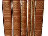 four books are lined up in a row on a white surface