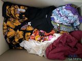 a cardboard box filled with clothes and clothing items
