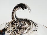 a silver plate with a bird on top of it