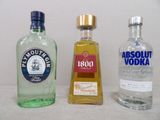trois bouteilles d'alcool posées les unes à côté des autres sur une table