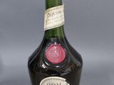 une image représentant une bouteille de cognac « Dom » sur fond gris