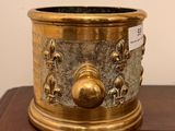 a gold planter sitting on a wooden table