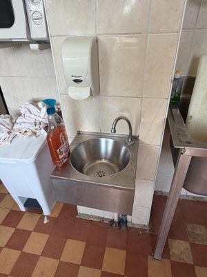 a sink in the corner of a public restroom