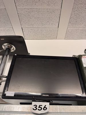 a flat screen tv sitting on top of a metal shelf