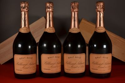 four bottles of wine are lined up on a red table