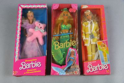 three barbie dolls are in a pink box on a table
