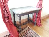une petite table recouverte de rideaux rouges dans une pièce