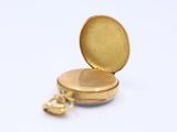 a small gold pocket watch with a chain around it