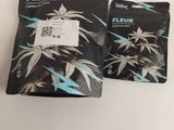 deux sachets de cannabis « fleur » posés sur une table blanche