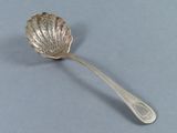 une cuillère en argent ornée d'une feuille, posée sur une table