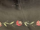 embroidery on a black shirt with pink flowers and green leaves