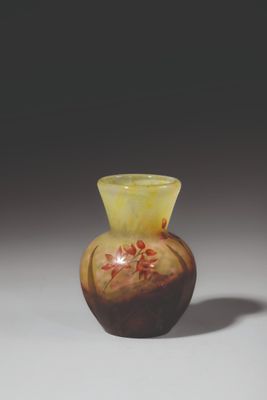 a brown vase with red flowers on it sitting on a table