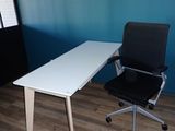 a white desk with a black chair in front of it