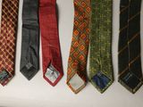 several ties are lined up on a white surface with a tag