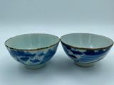 two blue and white bowls sitting side by side on a white surface