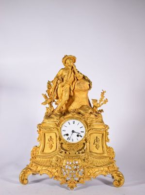 une horloge en or surmontée d'une statue