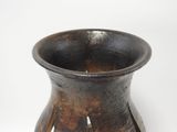 a brown vase that is sitting on a white surface