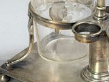 a silver plate with a glass on top of it