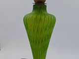 une lampe en verre vert avec un socle en bois et une ampoule au sommet