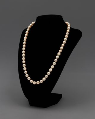 un collier de perles blanches sur un mannequin noir
