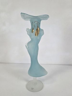a blue glass vase with a gold bell on it