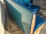 a blue couch sitting in the middle of a yard