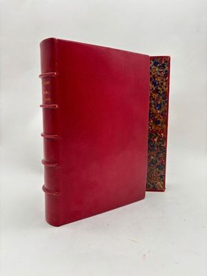 un livre rouge à la couverture rouge posé sur une surface blanche