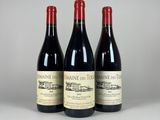 three bottles of wine are lined up on a table