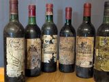 several bottles of wine are lined up on a wooden tray