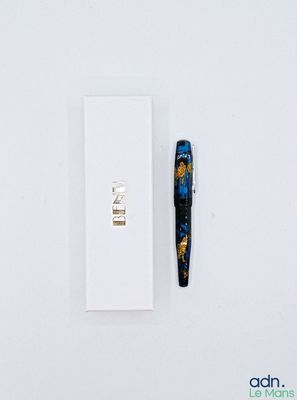 un stylo posé à côté d'une boîte sur une surface blanche