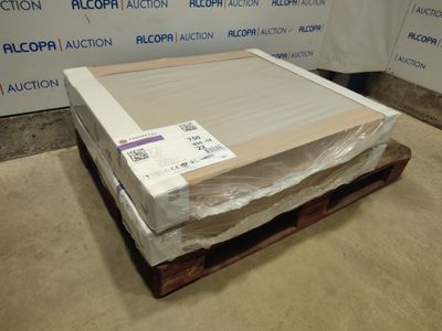 un carton contenant un matelas, posé sur une palette devant un mur