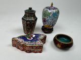 four pieces of cloissanted porcelain are sitting on a white surface