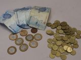une pile d'argent posée sur une table à côté d'une pile de pièces de monnaie