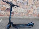 a scooter that is parked in front of a stone wall