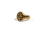 Gros plan sur une bague en or ornée d'une pièce de monnaie