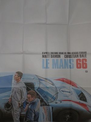 Affiche de cinéma française du film « Le Mans '66 », représentant deux hommes debout à côté d'une voiture de course