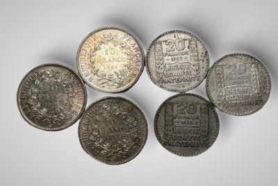 un groupe de cinq pièces d'argent sur une surface blanche
