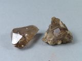 deux morceaux de quartz marron et blanc sur une surface grise