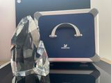 un trophée en cristal posé sur une table à côté d'une valise