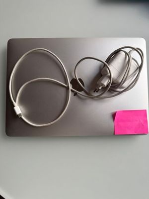 une photo d'un ordinateur portable sur lequel est collé un post-it rose