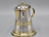 an antique silver coffee pot on a white surface