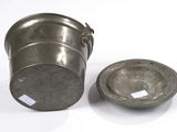an old metal container with a lid sitting next to a smaller metal container