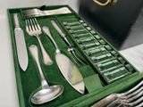 a green tray with silverware in it on a table