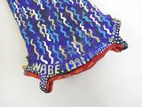 a blue and green scarf hanging on a white wall