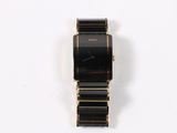 an image of a black and gold watch on a white surface